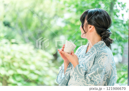 浴衣を着てお茶を飲む若い女性(茶道) 121986670