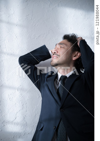 就活や転職、仕事のミスや人事が大変で頭を抱えショックをうけるスーツを着た男性 就活や転職、仕事のミスや人事が大変で頭を抱えショックをうけるスーツを着た男性 121988044