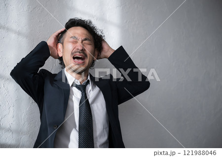 就活や転職、仕事が大変で頭を抱えショックをうけるスーツを着た男性 就活や転職、仕事が大変で頭を抱えショックをうけるスーツを着た男性 121988046