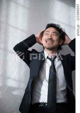 就活や転職、仕事が大変で頭を抱えショックをうけるスーツを着た男性 121988047