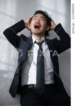 就活や転職、仕事が大変で頭を抱えショックをうけるスーツを着た男性 就活や転職、仕事が大変で頭を抱えショックをうけるスーツを着た男性 121988048