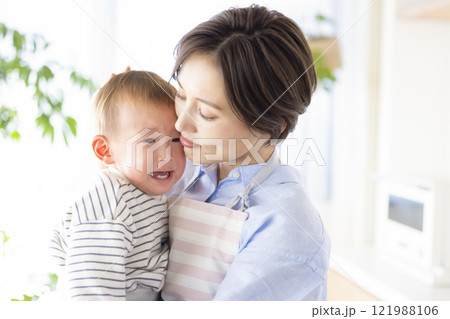泣いている赤ちゃんをあやすママ 泣いている赤ちゃんをあやすママ 121988106