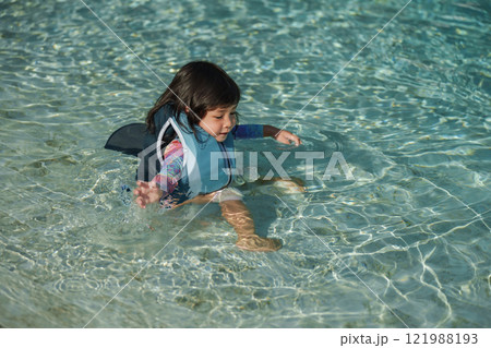 happy toddler baby girl in life jacket playing water in swimming pool happy toddler baby girl in life jacket playing water in swimming pool 121988193