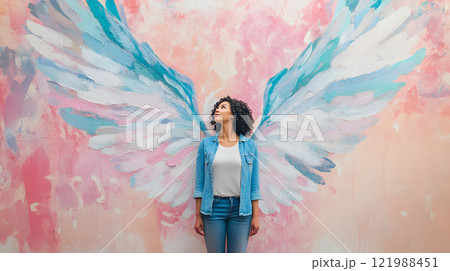 天使の羽が描かれた壁画の前に立つ女性 121988451