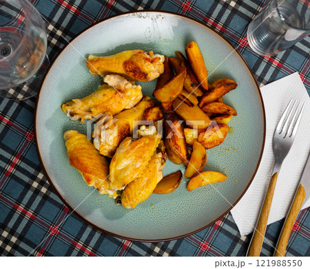Chiken wings and potato with serving pieces Chiken wings and potato with serving pieces 121988550