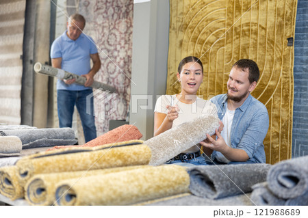 Husband and wife choose soft carpet together to create coziness in their home 121988689