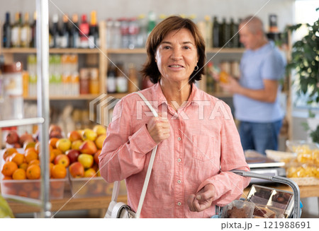 Elderly woman choosing food in grocery store 121988691