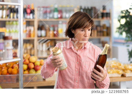 Mature woman choosing beer in grocery store 121988765