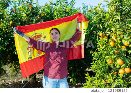 Girl football fan waving Spanish flag during tangerines harvest Girl football fan waving Spanish flag during tangerines harvest 121989125