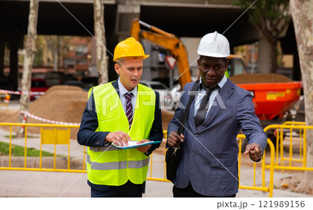 Foreman and engineer check correctness of the pipeline repair on street Foreman and engineer check correctness of the pipeline repair on street 121989156