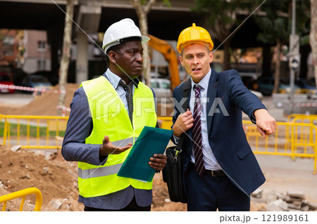 Young foreman shows someting to the african-american worker Young foreman shows someting to the african-american worker 121989161