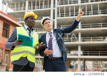 Architect and engineer talking about project of new building 121989182