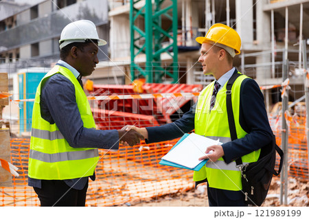 Architect and engineer construction workers shaking hands while working for teamwork and cooperation concept after finish an agreement in construction site 121989199