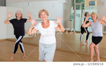 Senior women in sportswear dancing inside gym Senior women in sportswear dancing inside gym 121989218