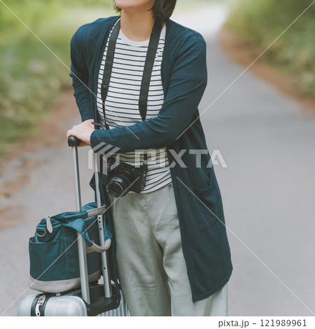 山道でスーツケースを転がす観光客 121989961