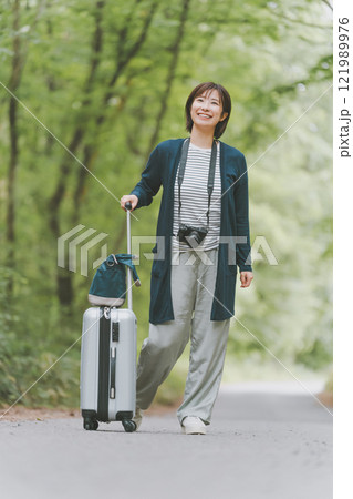 山道でスーツケースを転がす観光客 山道でスーツケースを転がす観光客 121989976