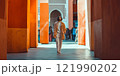 A person walks through colorful architectural columns under bright orange shades. The scene captures urban exploration and vibrant street style. Perfect for fashion and travel concepts. AI 121990202