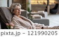 A serene moment of relaxation in a modern spa. This woman enjoys the tranquility of her surroundings while dressed in a cozy robe. Ideal for wellness and self-care themes. AI 121990205
