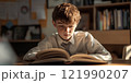 A young boy reading intently in a sunlit room. The atmosphere is calm and focused, with bookshelves in the background. This image captures the joy of learning and curiosity about knowledge. AI 121990207