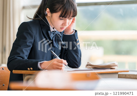 学校の教室・塾で試験・テストを受ける高校生・中学生・小学生の女の子(受験) 学校の教室・塾で試験・テストを受ける高校生・中学生・小学生の女の子(受験) 121990471