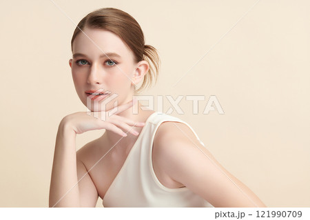 Beautiful young woman with clean fresh skin on beige background, Face care, Facial treatment, Cosmetology, beauty and spa, women portrait. Beautiful young woman with clean fresh skin on beige background, Face care, Facial treatment, Cosmetology, beauty and spa, women portrait. 121990709