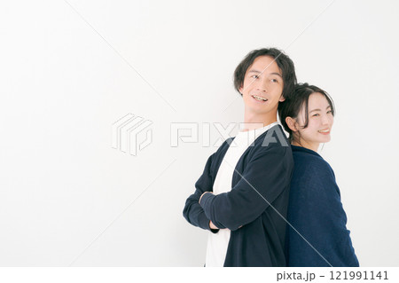 背中を合わせて微笑む若い男女 背中を合わせて微笑む若い男女 121991141