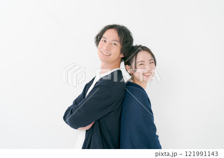 背中を合わせて微笑む若い男女 背中を合わせて微笑む若い男女 121991143