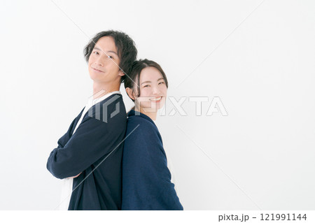背中を合わせて微笑む若い男女 背中を合わせて微笑む若い男女 121991144