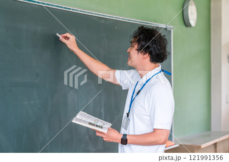 黒板の前で授業をする男性教師 121991356