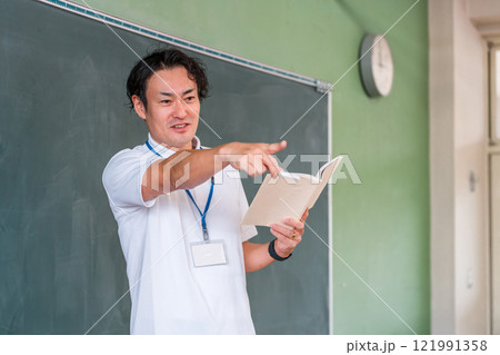黒板の前で授業をする男性教師 121991358