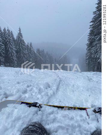 Snowy Ski Slope with Snowboard in Foreground Snowy Ski Slope with Snowboard in Foreground 121993281