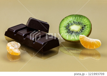 Chocolate with a slice of kiwi and mandarin slices close up Chocolate with a slice of kiwi and mandarin slices close up 121993709