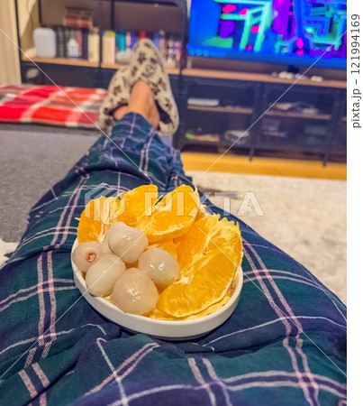 A cozy evening at home with a plate of juicy oranges and lychees. High quality photo 121994169