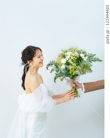 ブーケを渡されて喜ぶウェディングドレスを着た女性　ブライダルフォト　前撮り 121994685