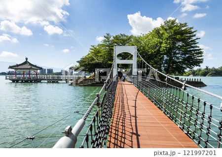 View of the suspension bridge leading to Fu Guo Island at Chenghcing Lake Scenic Area in Kaohsiung, Taiwan. View of the suspension bridge leading to Fu Guo Island at Chenghcing Lake Scenic Area in Kaohsiung, Taiwan. 121997201