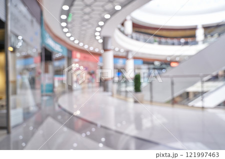 Modern shopping mall interior with blurred storefronts and elegant architecture 121997463
