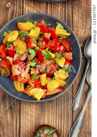 Fresh salad preparation with tomatoes and greens. 121997707