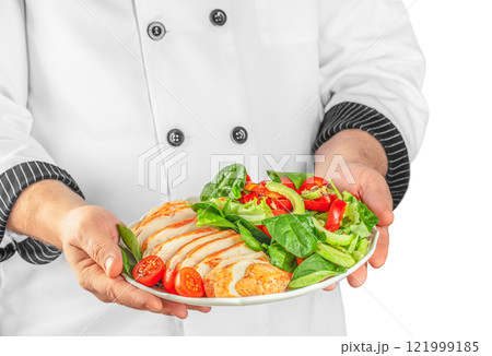 Chef hands preparing delicious avocado salad with grilled chicken fillet isolated on white background Chef hands preparing delicious avocado salad with grilled chicken fillet isolated on white background 121999185