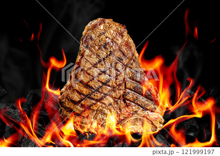 Beef T-bone steaks on BBQ grill coal. porterhouse steak or T Bone Steak with fire flames. Barbecue and grill concept 121999197