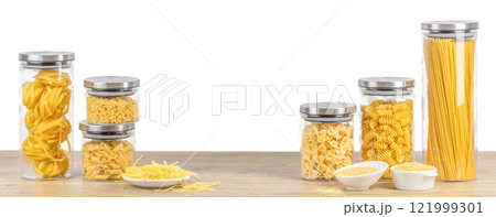 variety of raw dry pasta in glass jars on a wooden table isolated on white. Long banner format. copy space variety of raw dry pasta in glass jars on a wooden table isolated on white. Long banner format. copy space 121999301