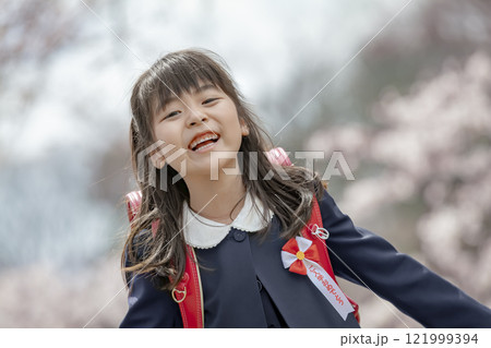 桜の咲く公園を楽しむランドセル姿の一年生 121999394