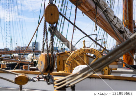 Ship rigging and wheel in nautical setting 121999668