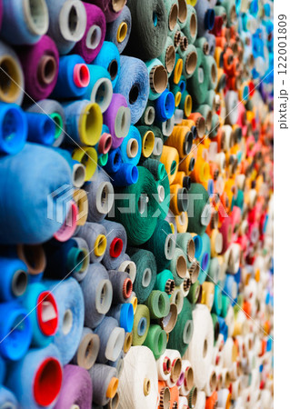 An Array of Colorful and Vibrant Spools of Thread Stacked Neatly in a Textile Shop Display 122001809