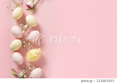 Easter frame with colorful pastel eggs and spring flowers on pink background. Flat lay. Happy Easter greeting card with copy space. Top view. 122001833