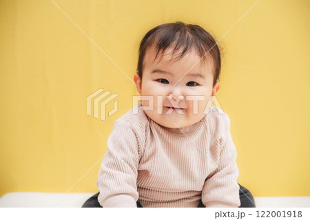 黄色バックでお座りする赤ちゃん 黄色バックでお座りする赤ちゃん 122001918
