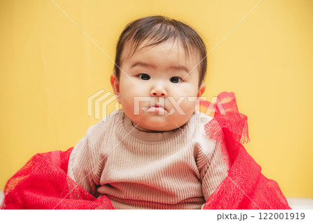 黄色バックでお座りする赤ちゃん 122001919