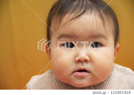 黄色バックでお座りする赤ちゃん 黄色バックでお座りする赤ちゃん 122001928