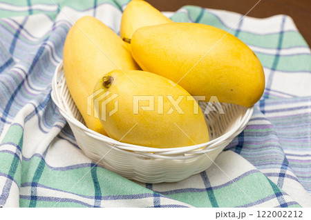 Fresh sliced, cut, diced ripe mango on gray table background with leaf for eating. Fresh sliced, cut, diced ripe mango on gray table background with leaf for eating. 122002212