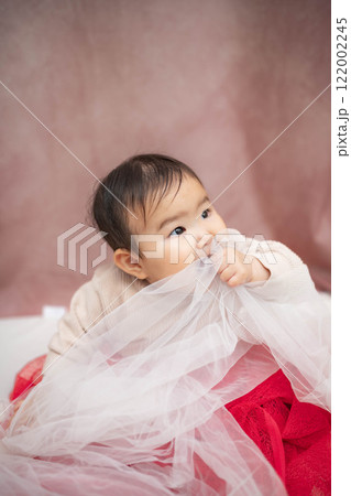 ピンクバックで座っている赤ちゃん 122002245
