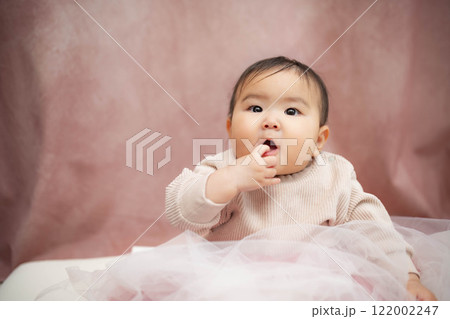 ピンクバックで座っている赤ちゃん ピンクバックで座っている赤ちゃん 122002247